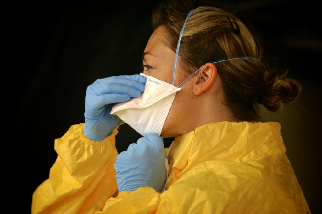 Healthcare professional wearing PPE and mask for protection against COVID-19.