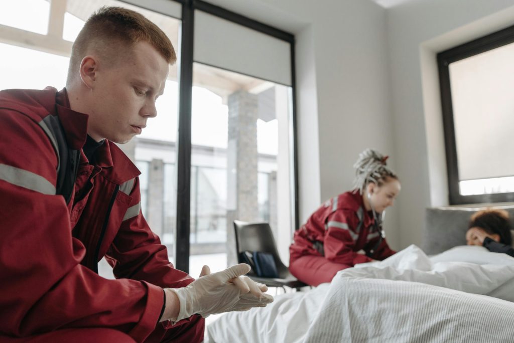 EMTs assessing and caring for a patient in an indoor setting, professional healthcare.